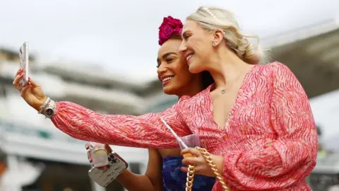 Reuters Two women take a selfie at Aintree Ladies Day 2024