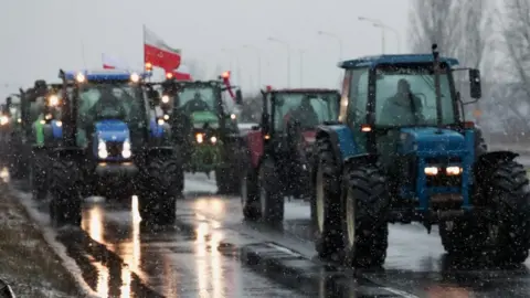 REUTERS/Kacper Pempel Polish farmers slow down traffic on a road with tractors during a protest over price pressures, taxes and green regulation, grievances shared by farmers across Europe, in Poznan, Poland