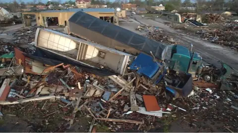 Trucks on buildings after tornado in Rolling Fork