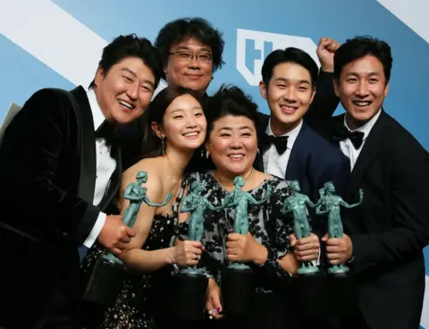 AFP Director Bong Joon-ho stands behind the cast of Parasite