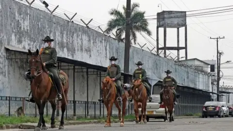 EPA A handout photo made available by the Villavicencio Mayor's Office, shows a group of police officers patrolling the exterior of the Villavicencio Prison, in Villavicencio, Colombia, 21 March 2020