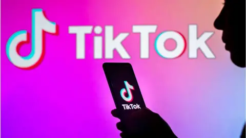 Getty Images Person's silhouette in front of TikTok logo