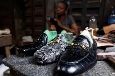 MARVELLOUS DUROWAIYE/REUTERS Shoes made by Ifunanya Ifwobu for a client lay on a table at her workshop.