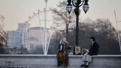 Getty Images Two people sitting on a wall talking