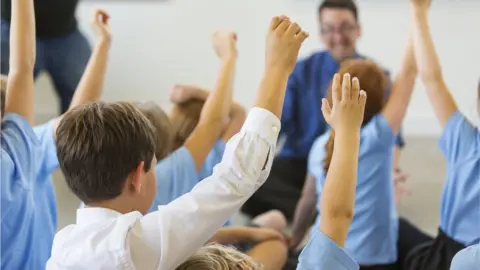 davidf kids raise hands in class to male teacher