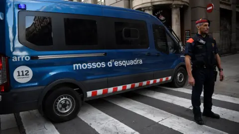 AFP Officer of the Catalan police force stands by a squad van in Barcelona.