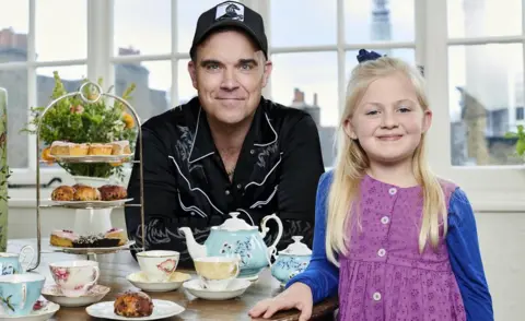 PA Media Robbie Williams and Clara Ross