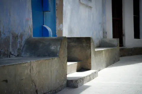 Alamy Seats outside house in Stone Bridge, Zanzibar