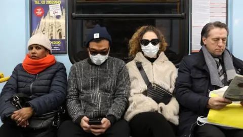Two passengers of the subway are wearing a protective mask on February 26, 2020 in Milan, Italy
