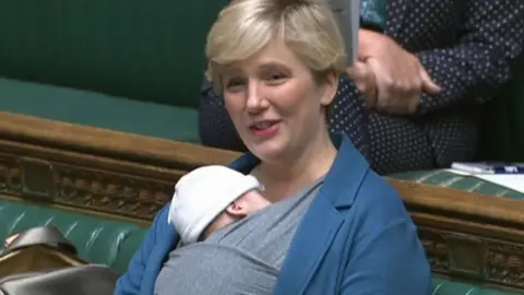 PA Media Stella Creasy with her son in the Commons in September