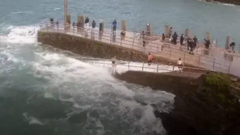 People playing on harbour wall and slipway