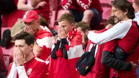 Getty Images Denmark fans were visibly upset as Eriksen received treatment on the pitch