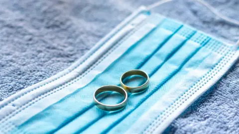 Getty Images Wedding rings on a face mask