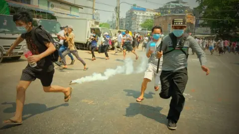 Getty Images Security forces intervene in protesters as they gather to protest against the military coup in Yangon