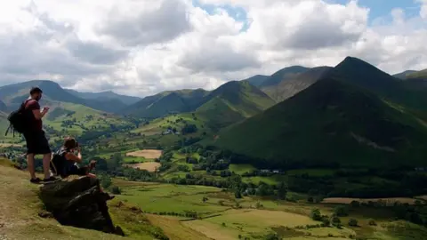 Getty Images Two people on Cumbria mountains with their phone