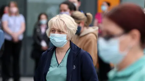 PA Media Staff observe a minute's silence outside the Queen Elizabeth University Hospital