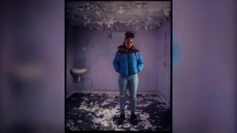 Tia stands in former cell block and features in the exhibition