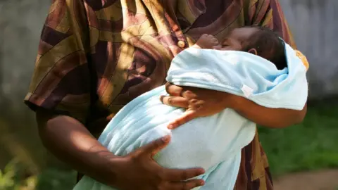 Getty Images A archive image of a Sri Lankan woman holding a wrapped up baby, both are anonymous and cropped