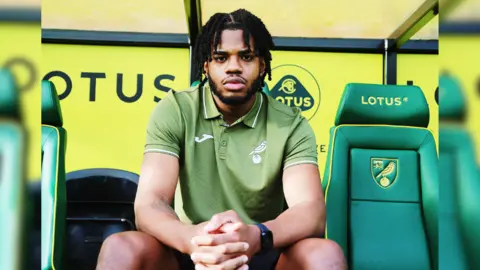 Norwich City Football Club Jayden St Paul sat in the Norwich City FC dugout