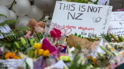 Getty Images Messages and flowers are left near Al Noor mosque on March 17, 2019 in Christchurch, New Zealand