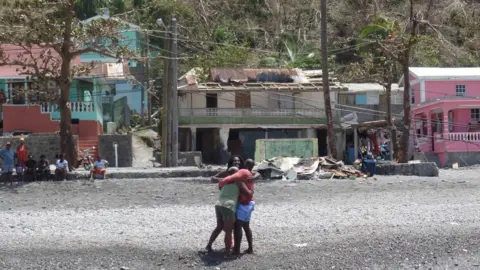 Gemma Handy Glen Hector is greeted by his mother and sister upon arriving home in Scott's Head loaded with supplies from Antigua