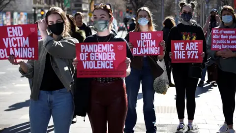 Reuters Women display signs to protest against violence