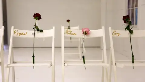 EPA Three white chairs with the names of those killed