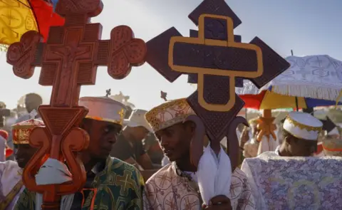 Getty Images Orthodox Christians, wearing traditional clothes, celebrate the Feast of Baptism (Epiphany) near the Lake Dambal of Oromia, Ethiopia as they pray and sing hymns as part of celebration on January 18, 2023.