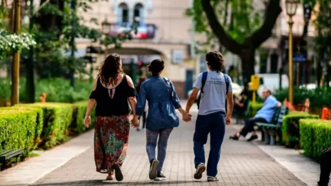 Getty Images Three people holding hands