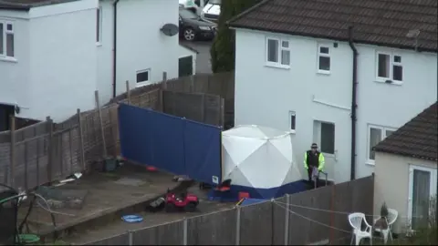 BBC The back garden of the house in Sea Mills with a white forensic tent and blue screen