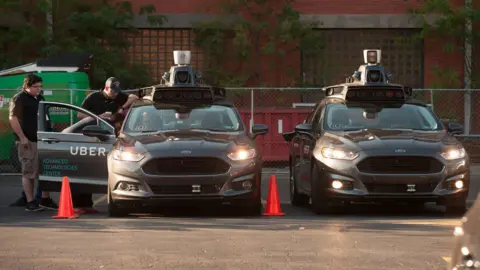 Getty Images Uber driverless cars and crew members