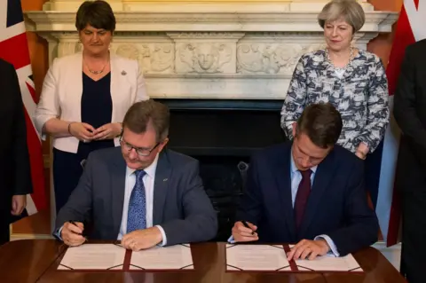 Reuters The deal was signed in Downing St by DUP MP Sir Jeffrey Donaldson and Tory Chief Whip Gavin Williamson