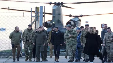 PA Media Volodymyr Zelensky and Rishi Sunak arrive at a base in Dorset