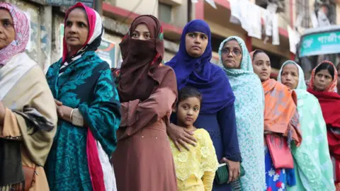 Reuters Female voters with children stand in a queue at a voting centre in Dhaka