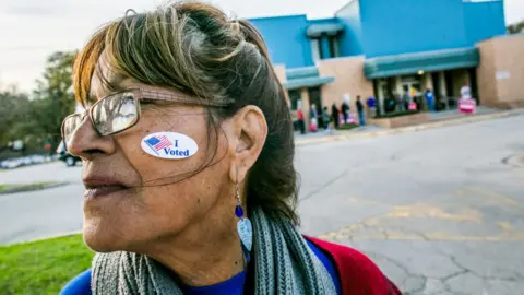 Getty Images Woman with "I Voted" sticker on face