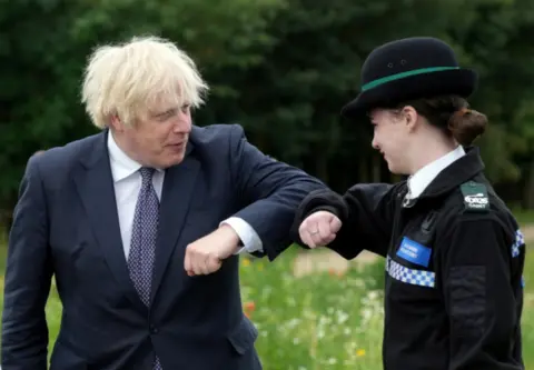 Christopher Furlong/Pool via REUTERS Boris Johnson greets a police officer