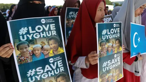 Getty Images Uighur protesters in Indonesia in 2018 hold signs reading #LoveUyghur and #SaveUyghur