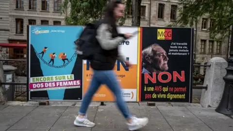Getty Images Man walks past campaign posters