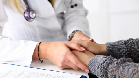 Getty Images GP holding hands of patient