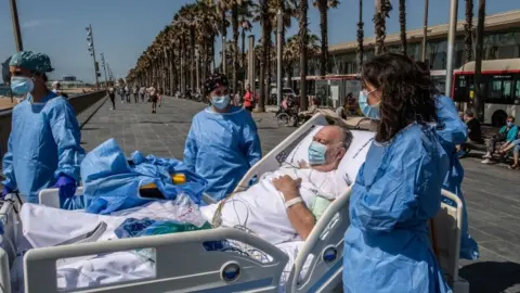 Getty Images Doctors in Barcelona take coronavirus patients to the beach