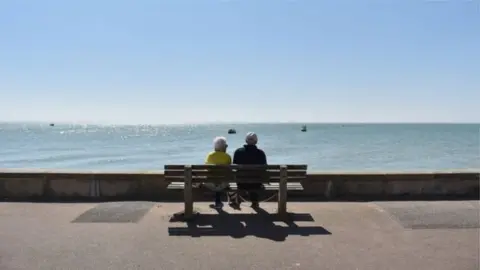 Getty Images A man and woman sitting on a bench