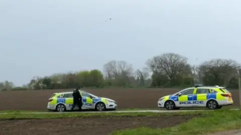 Police cars on a road near an abattoir