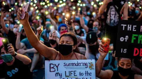 Getty Images Protesters hold up their phones during a demonstration over the death of George Floyd