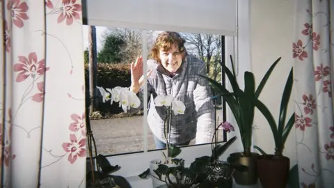 Mavis Dunford Mavis' friend Heather waves through the window at her