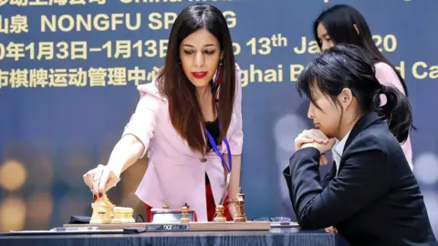 Getty Images Shohreh Bayat (L) prepares for a match at the 2020 International Chess Federation (FIDE) Women's World Chess Championship in Shanghai, 11 January 2020