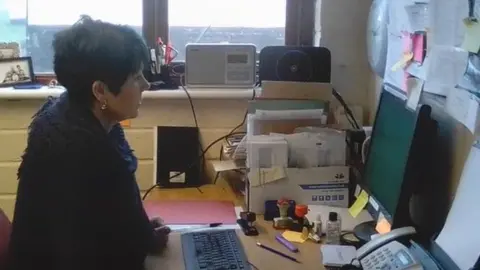 Andrew Sadler  Cressida Sadler at her desk, using her computer