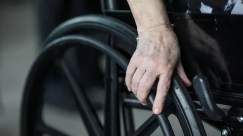 Getty Images unidentified person holding wheelchair wheel