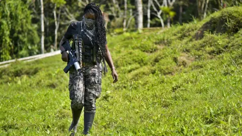 Getty Images A National Liberation Army guerrilla walks in the bush, in Colombia