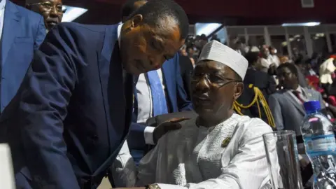 AFP Chadian President Idriss Deby (R) speaks with Congo's President Denis Sassou Nguesso during the opening ceremony of the African Union summit at the Palais des Congres in Niamey, on July 7, 2019.