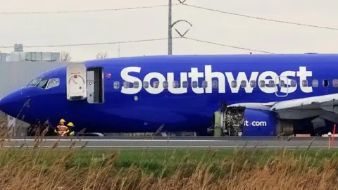 Reuters Emergency personnel monitor the damaged engine of Southwest Airlines Flight 1380, which diverted to Philadelphia International Airport. 17 April 2018